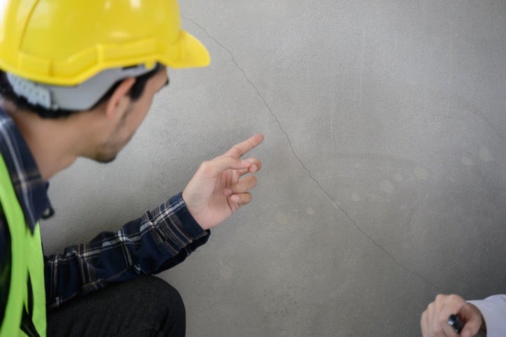 Technician inspecting concrete crack